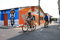 騎著腳踏車瀏覽社區居民的住家與圍籬牆面的描繪