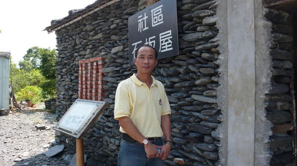 推動有情優質的大進社區，理事長張文仁在石板屋前留影。